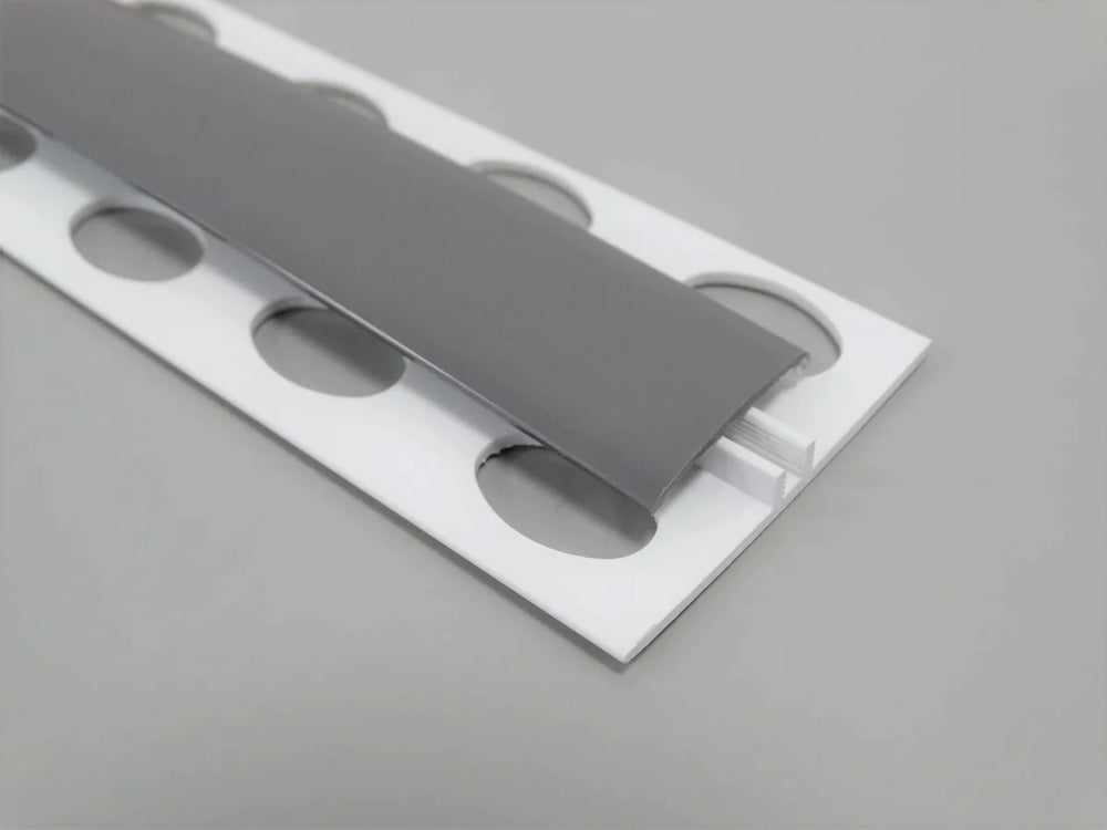 Élément de jonction en PVC gris titane, type H, conçu pour des finitions raffinées et robustes.