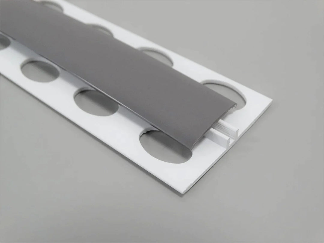 Élément de jonction en PVC gris titane, type H, conçu pour des finitions raffinées et robustes.