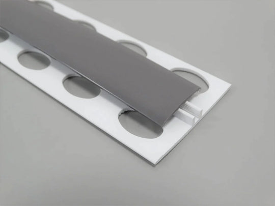 Élément de jonction en PVC gris titane, type H, conçu pour des finitions raffinées et robustes.