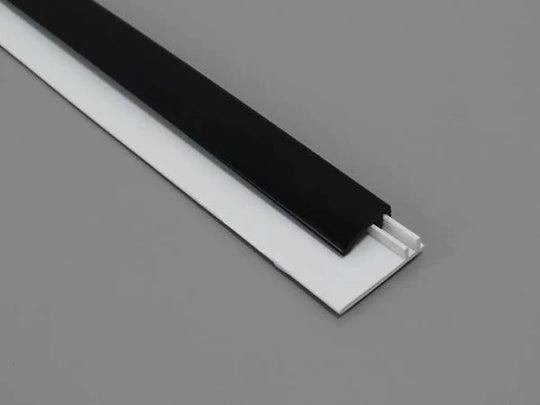 Profil de bord à clipser en deux parties, en PVC noir, idéal pour des finitions pratiques et modernes.